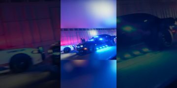 Police cars with flashing lights at night.