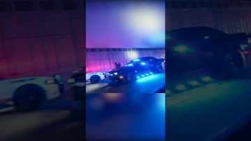 Police cars with flashing lights at night.