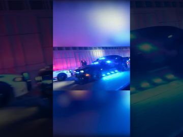 Police cars with flashing lights at night.