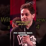 Comedian on stage with microphone, humorous roasting.