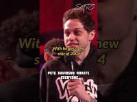 Comedian on stage with microphone, humorous roasting.