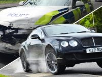 Black car speeds past damaged police vehicle.