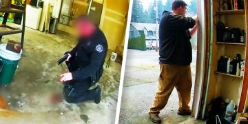 Police officer kneeling with gun inside garage.