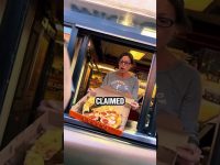 Woman surprised holding takeaway pizza box in drive-thru.