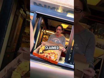 Woman surprised holding takeaway pizza box in drive-thru.