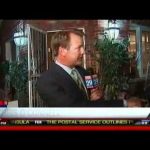 Reporter conducting outdoor interview at night.