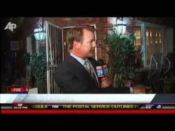Reporter conducting outdoor interview at night.