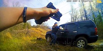 Person points gun at SUV in rural area.