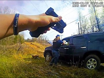 Person points gun at SUV in rural area.