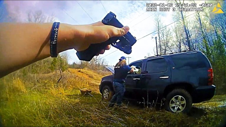 Person points gun at SUV in rural area.