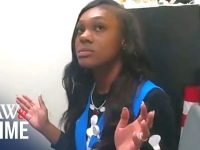 Person in office setting, hands raised, looking up.