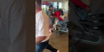 People in store with strollers and shopping bags.