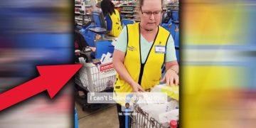 Store employee at checkout counter with cart.