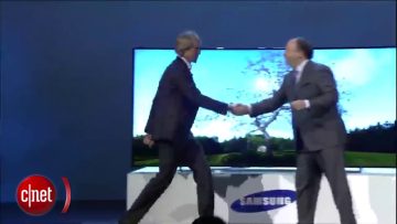 Two executives shaking hands at Samsung event.