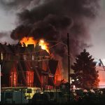 Firefighters battling roof fire at night