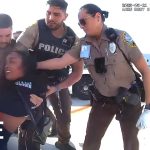 Police detaining person at airport runway.