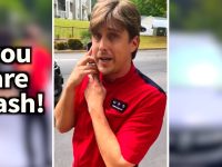 Person in red shirt looking surprised outdoors.