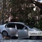 Police arrest beside silver car at traffic light.