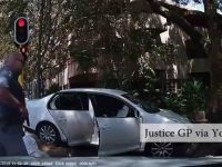 Police arrest beside silver car at traffic light.