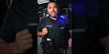 Person wearing tactical gear with equipment.