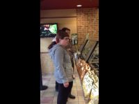 People waiting in line at a sandwich shop.