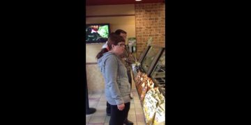 People waiting in line at a sandwich shop.