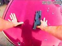 Person securing handgun on red car hood.