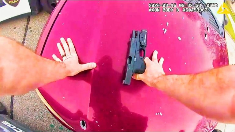 Person securing handgun on red car hood.
