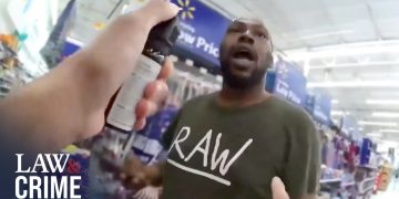 Person in store with spray can, Walmart signs visible.