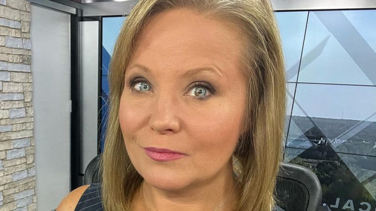 Person in news studio setting, close-up view.