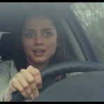 Woman looking surprised while driving a car.