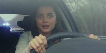 Woman looking surprised while driving a car.