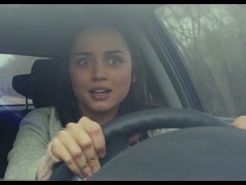 Woman looking surprised while driving a car.