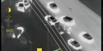 Aerial infrared view of cars on a highway.