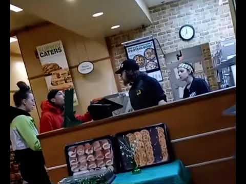 Subway employees interacting with customers at the counter.
