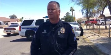 Police officer at scene with patrol cars