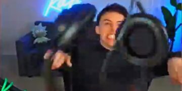 Person excitedly holding VR headset indoors.