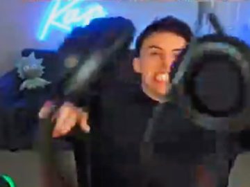 Person excitedly holding VR headset indoors.