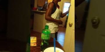 Woman talking in kitchen holding door.