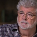 Man with glasses and gray beard in checkered shirt.