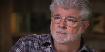 Man with glasses and gray beard in checkered shirt.