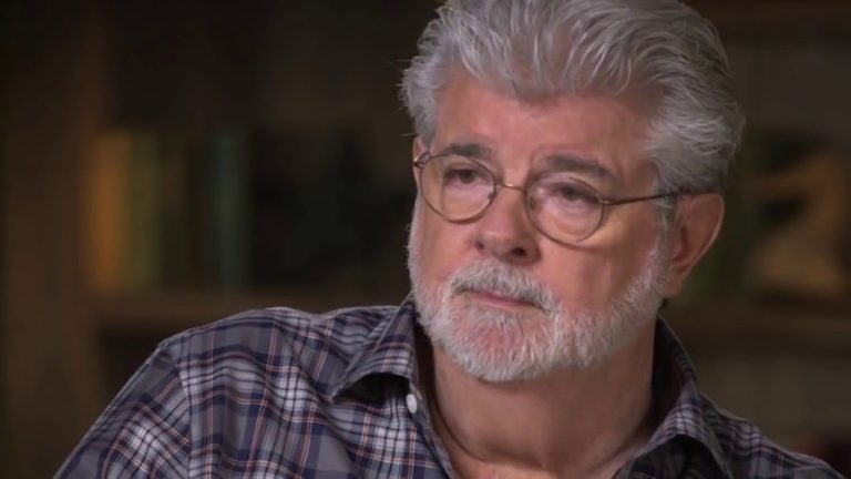 Man with glasses and gray beard in checkered shirt.