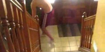 Person slipping at bottom of staircase indoors.