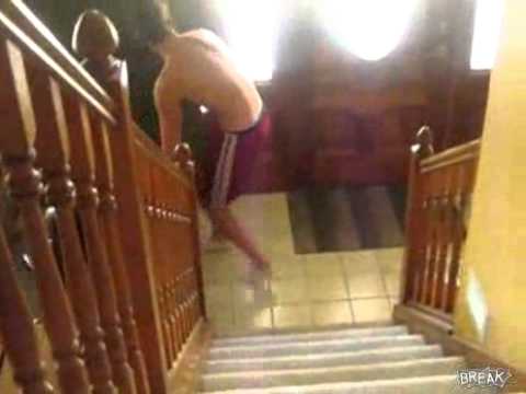 Person slipping at bottom of staircase indoors.