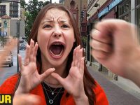 Woman shouting on city street with blurred fists.