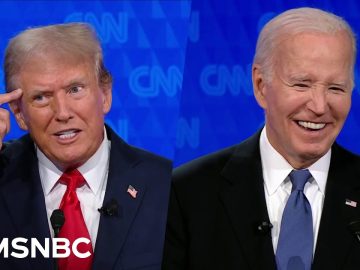 Two men in suits on TV debate screen.