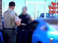 Sheriff talking to person by blue car
