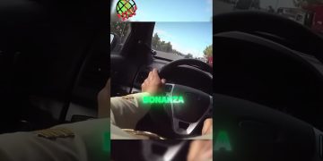 Person driving car on highway, steering wheel view.