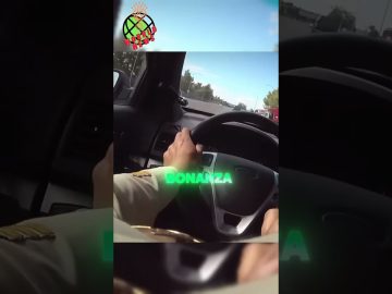 Person driving car on highway, steering wheel view.