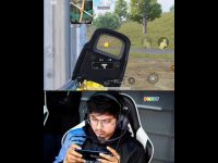 Person playing mobile shooting game with focus